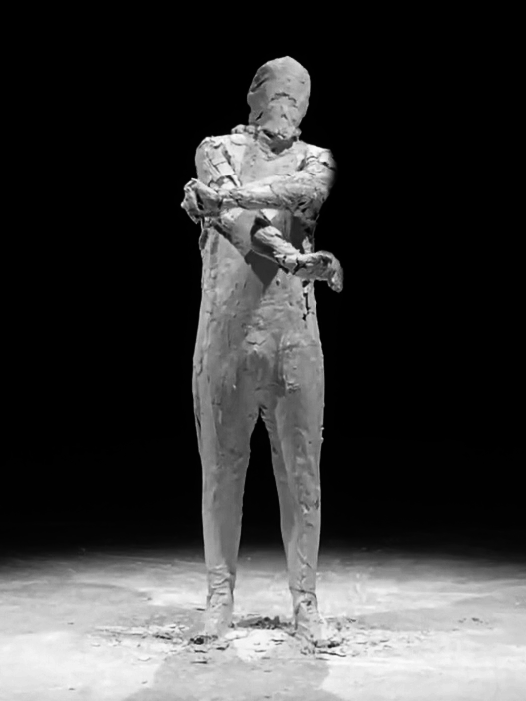 image of the performance titled the creation depicting a body which is covered with craked ceramics