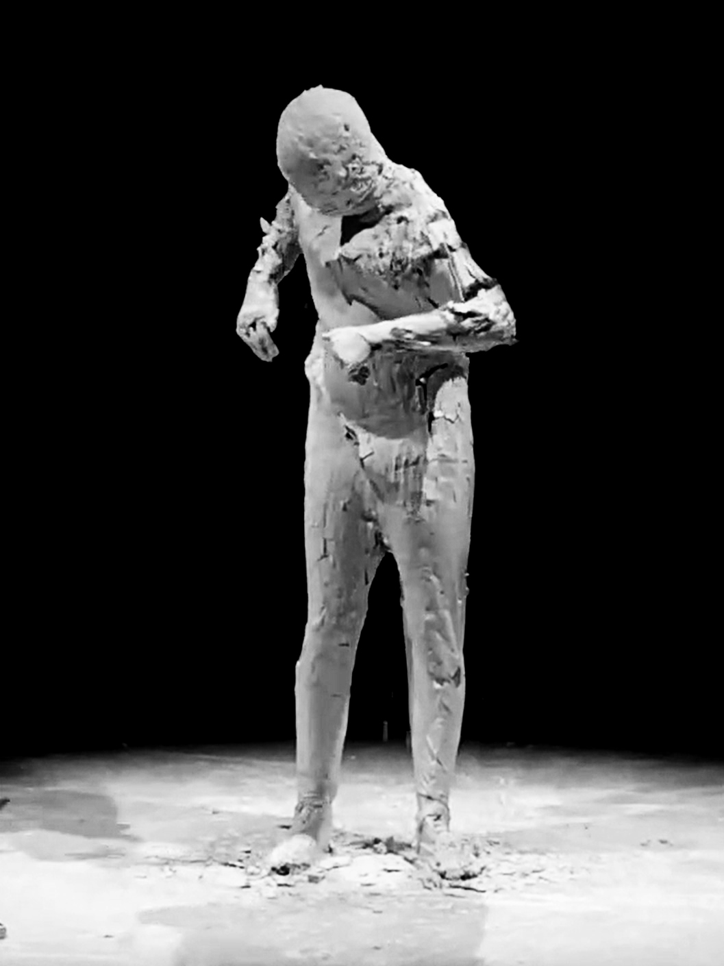 image of the performance titled the creation depicting a body which is covered with craked ceramics